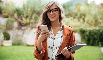 Portrait of a smiling woman holding mobile phone